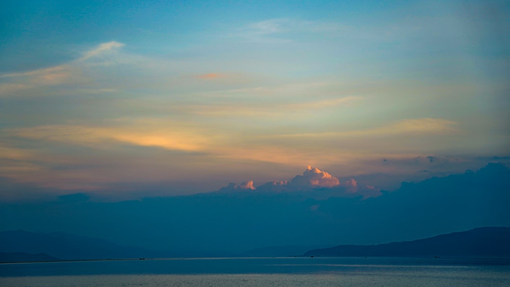 a body of water with mountains in the background