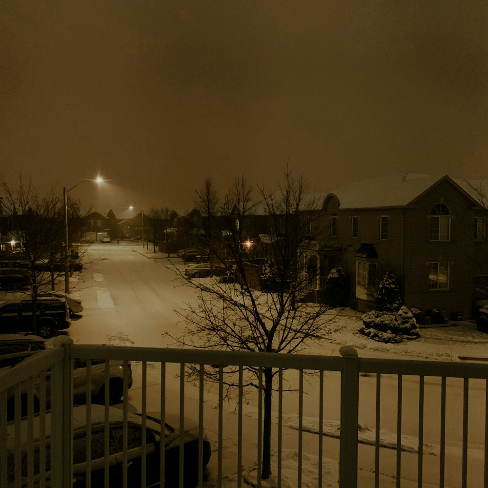 a snowy street with houses and trees