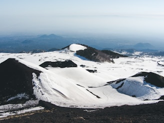 a snowy mountain with a river running through it