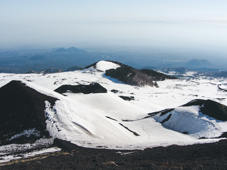 a snowy mountain with a river running through it
