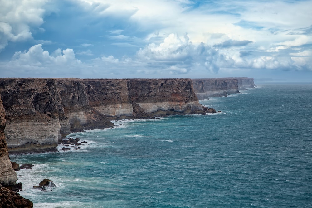 a cliff with a body of water below