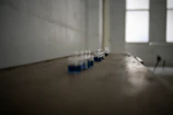 Soft-focus image of laboratory glassware with blue and green lighting accents.
