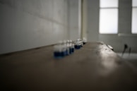 A pristine laboratory setup with amber glass bottles filled with chili extract oleoresin under bright clinical lighting.