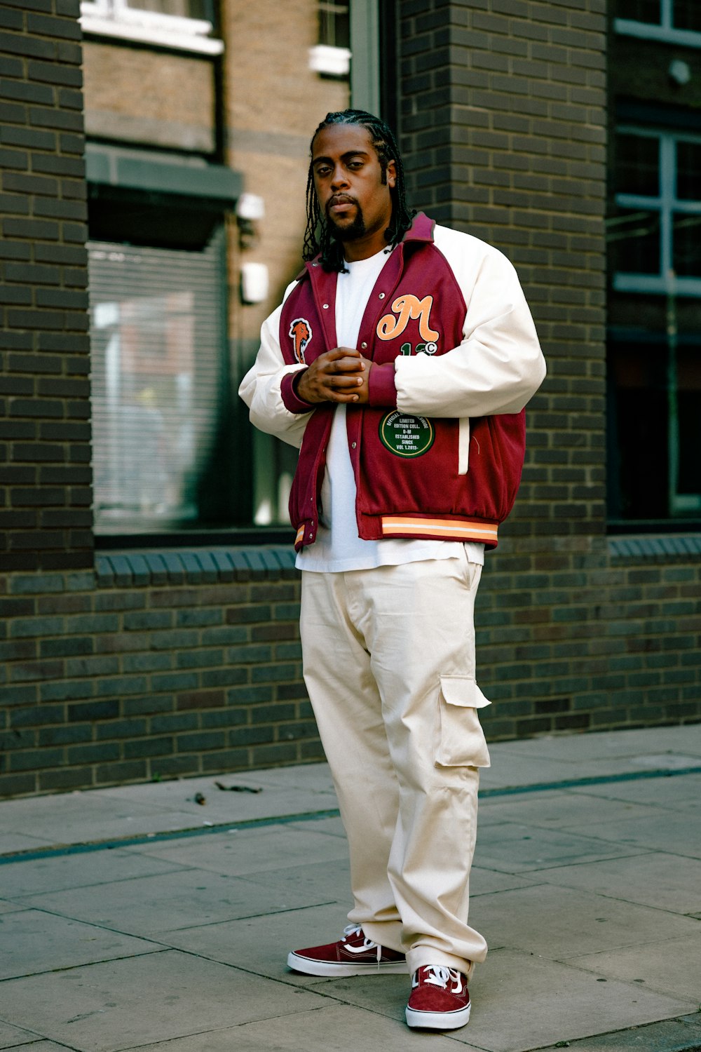 a man wearing a red and white uniform and standing on a sidewalk