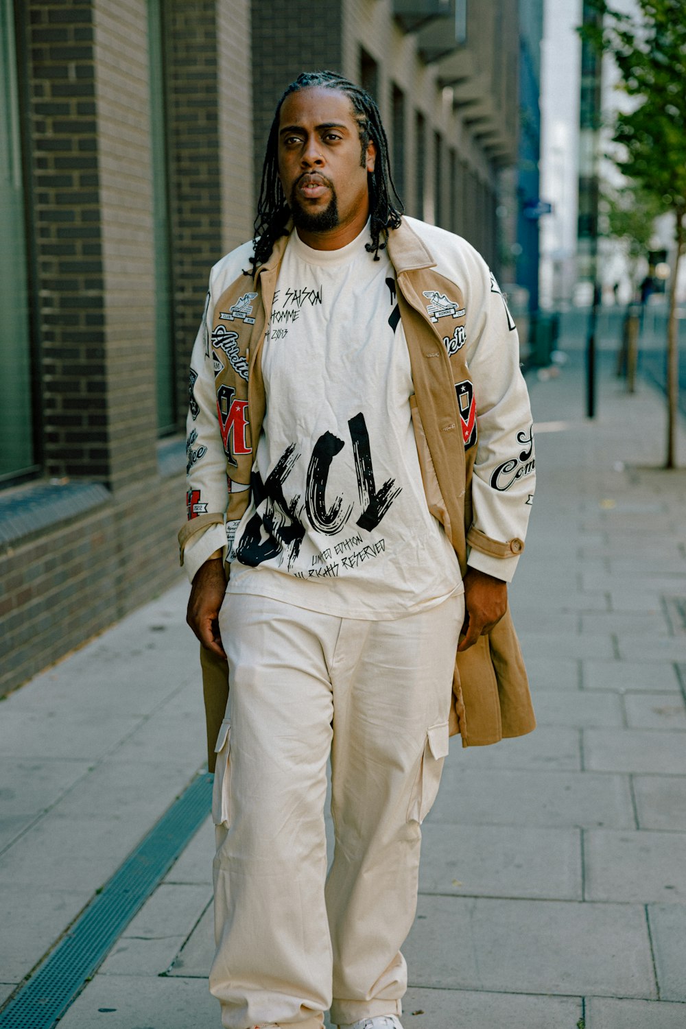 a man wearing a white jacket and white pants