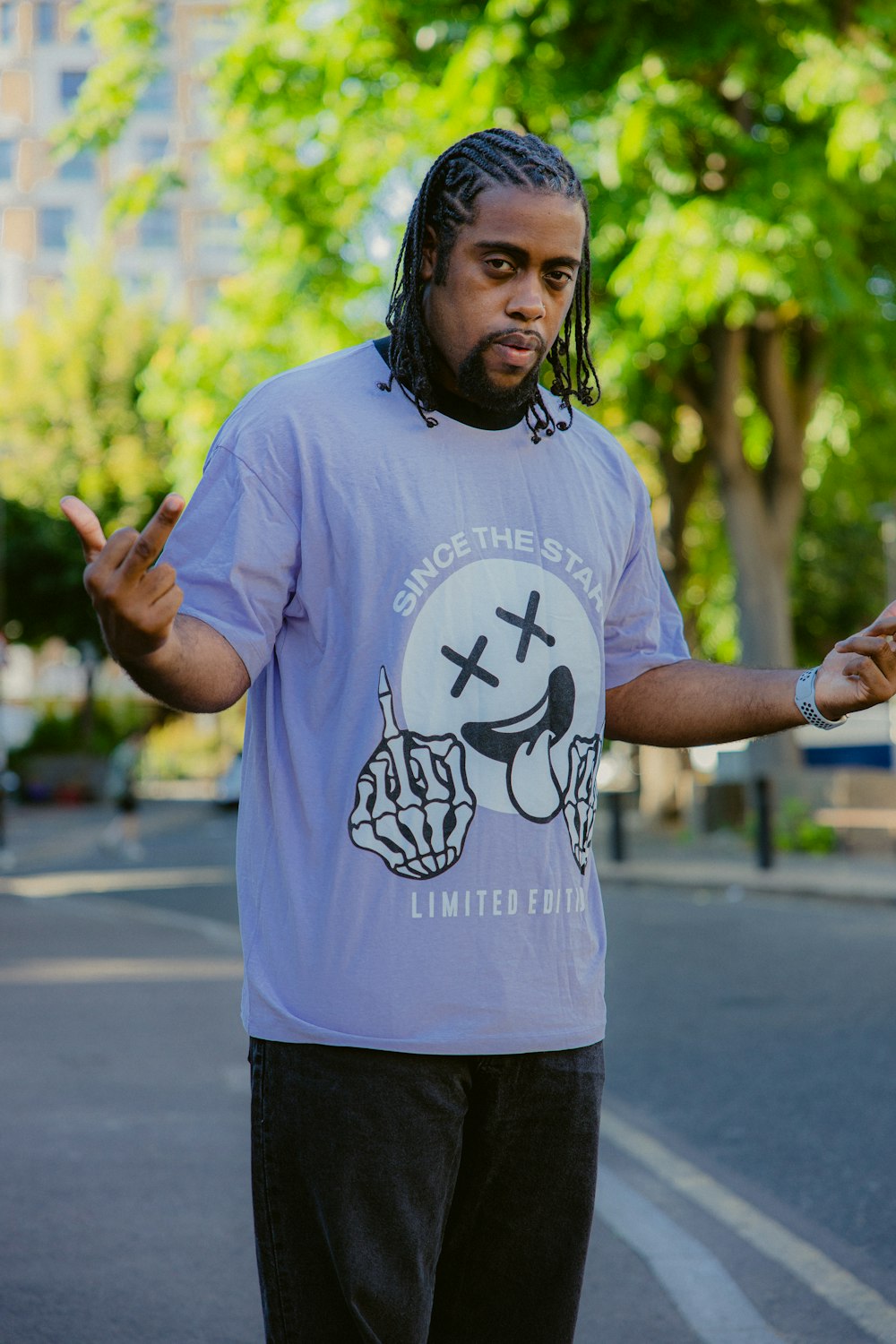 a man with long hair and a beard holding his hands up