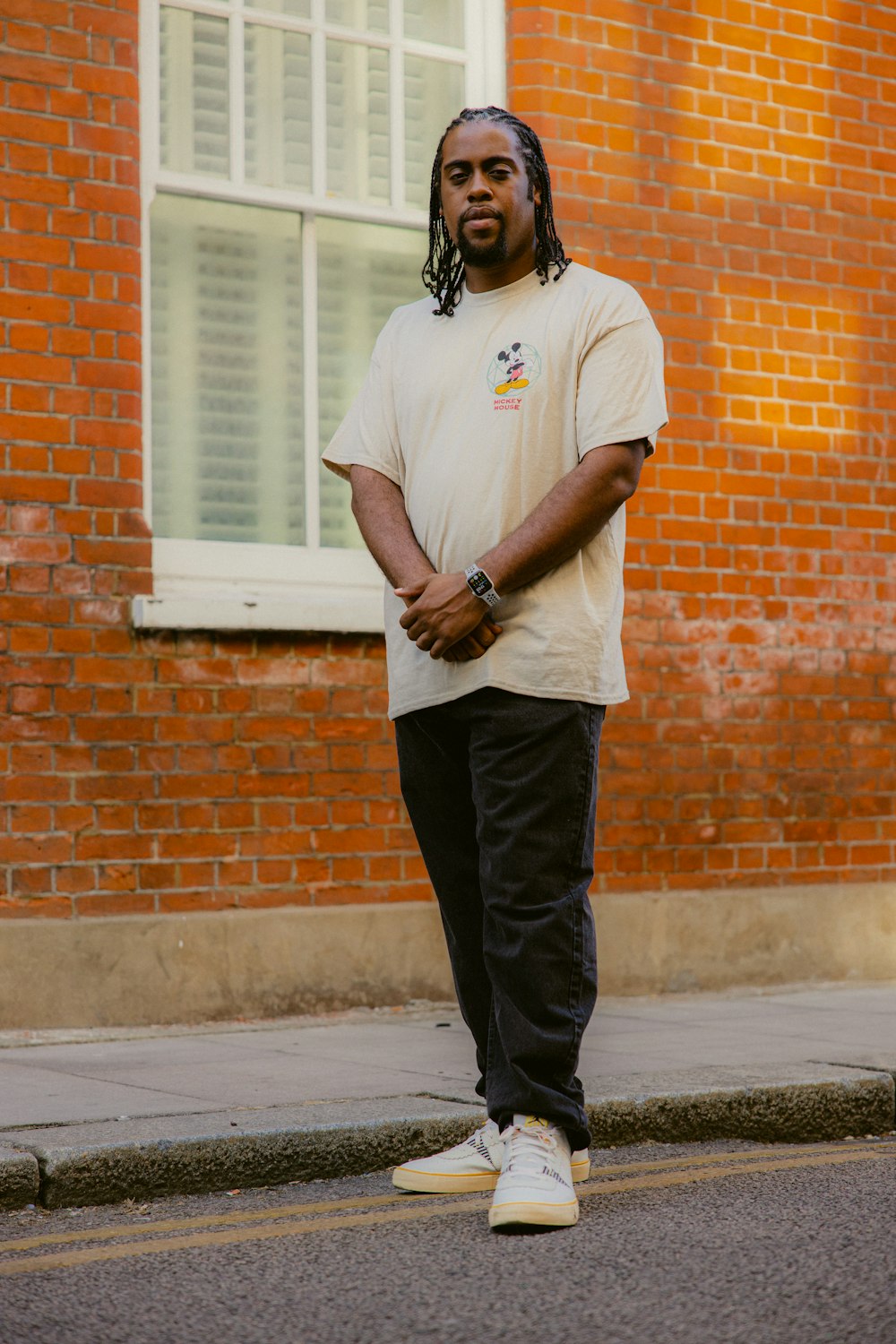 a man standing in front of a brick building