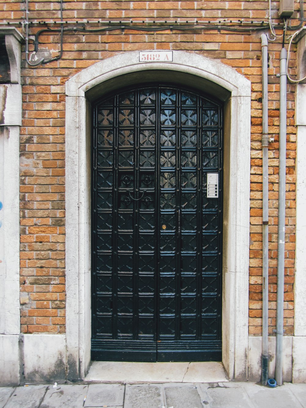 Una puerta negra en un edificio de ladrillo