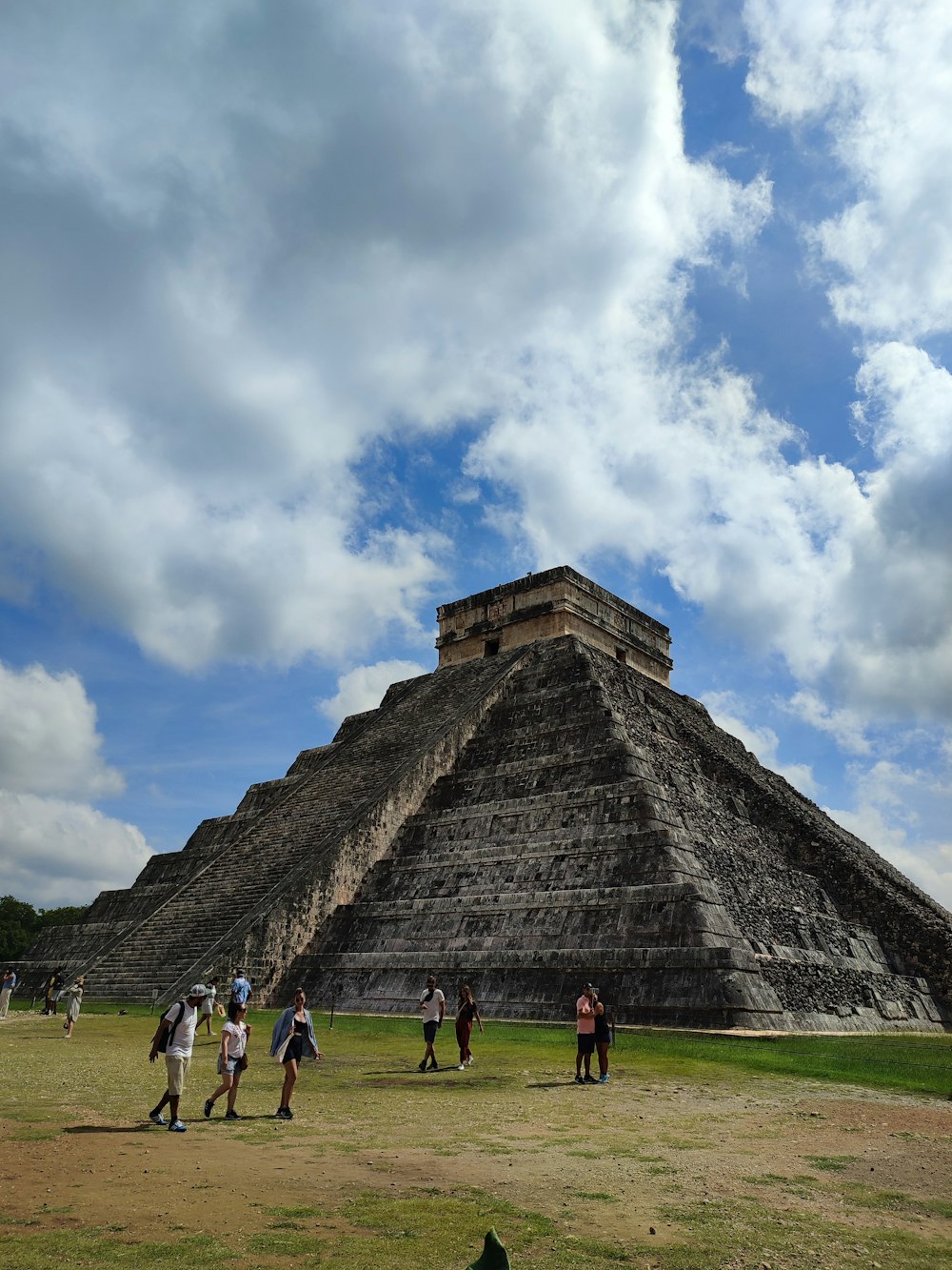 a group of people standing in front of a pyramid