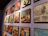 A wall features a collection of framed vinyl record covers, arranged in a neat grid. The covers showcase a variety of designs and colors, each featuring different musical artists and album titles. The overall setting appears to be in a gallery or a music-themed room.