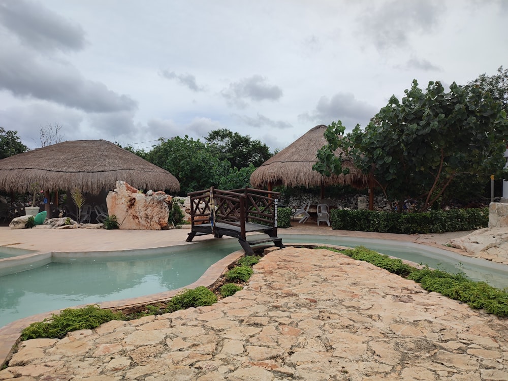 a pool with straw huts