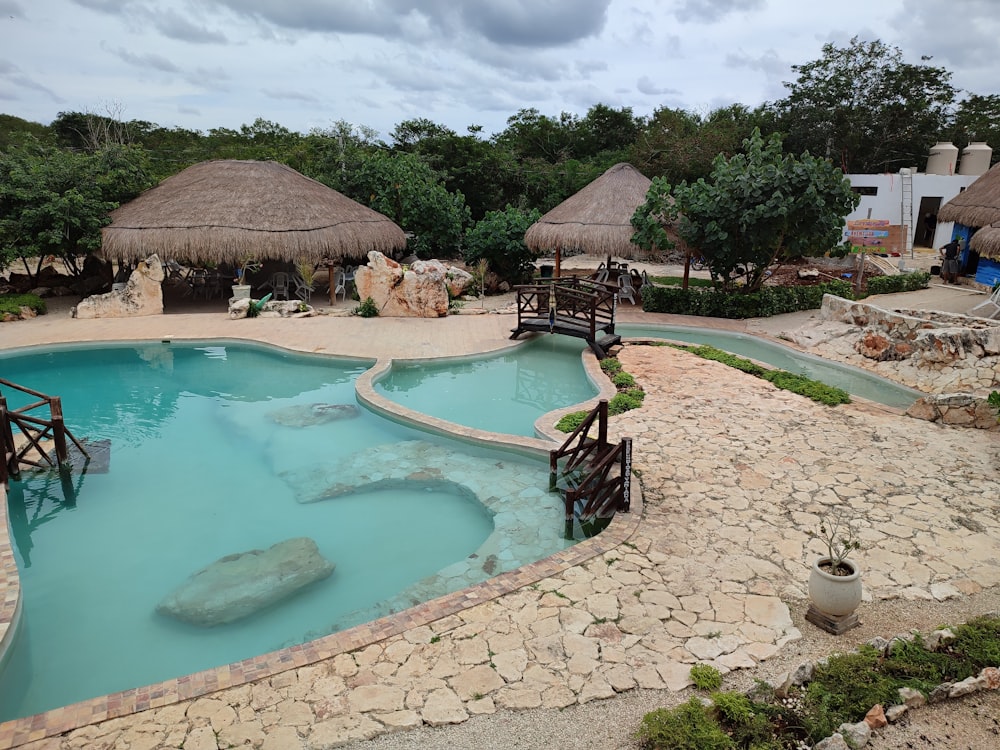 a pool with rocks and a hut