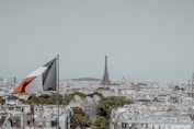 The Eiffel Tower in Paris with the French flag waving nearby.
