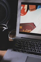 An artist reviewing animated comic shorts on a large monitor with a cup of coffee nearby.