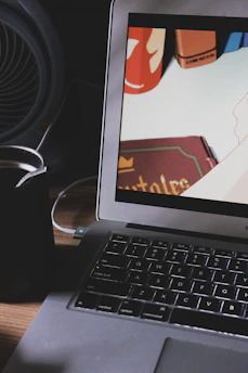 An artist reviewing animated comic shorts on a large monitor with a cup of coffee nearby.