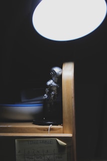 A cute robot sitting on a desk with a glowing light.