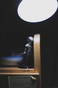 A cute robot sitting on a desk, glowing softly while displaying notifications.