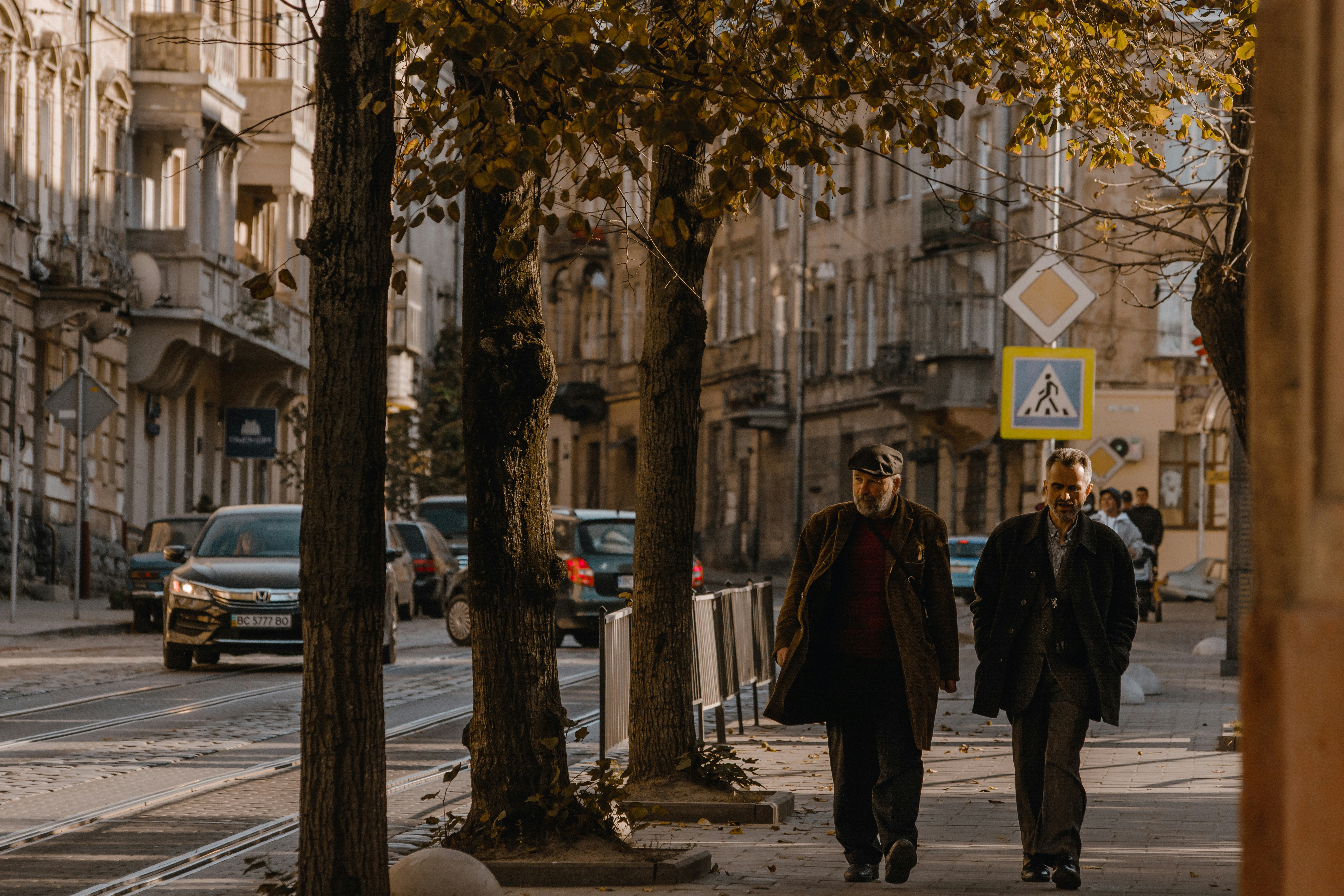 a couple of men walking down a sidewalk