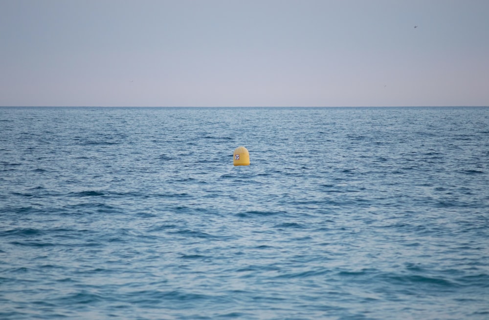 a yellow buoy floating in the ocean