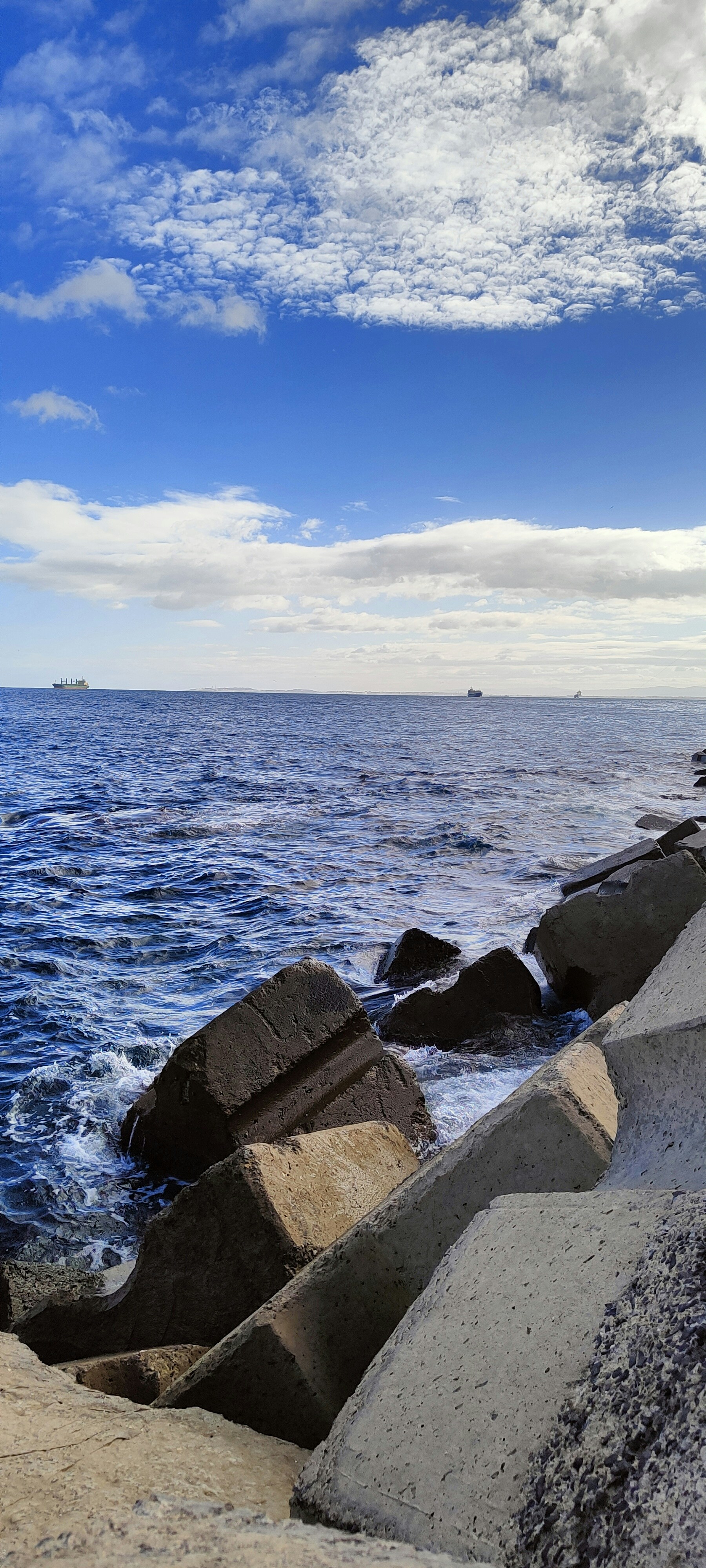 Un rivage rocheux avec un bateau au loin photo – Photo Ciel Gratuite ...