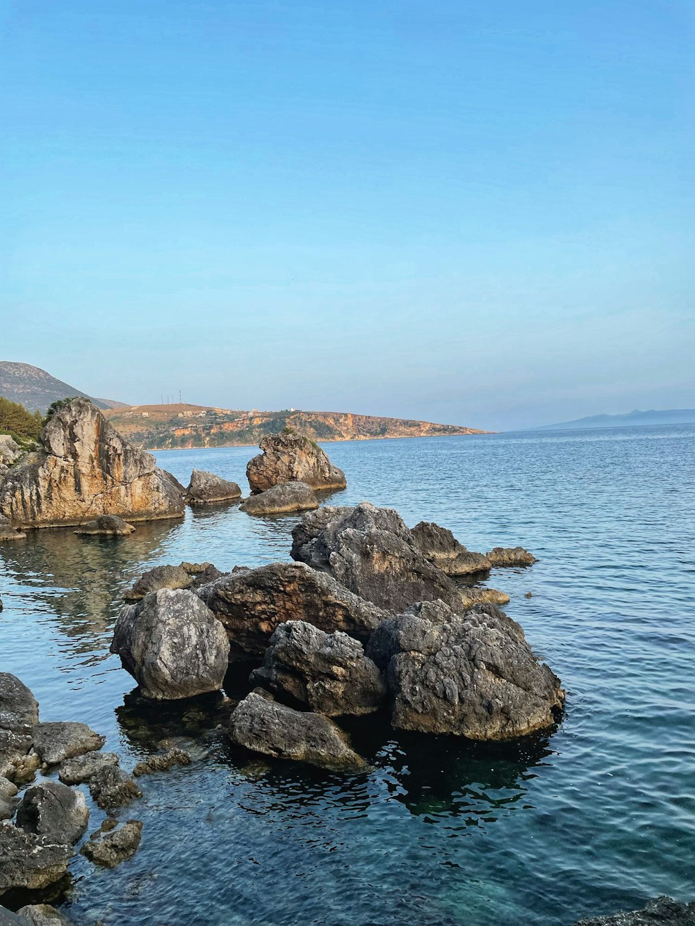 a rocky shoreline with a body of water in the background