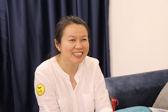 A user applying a GLP-1 patch while smiling in a bright, cozy room