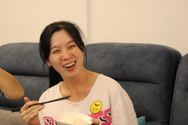 A smiling office worker enjoying a wholesome meal from Laxmi Tiffin Service at their desk.