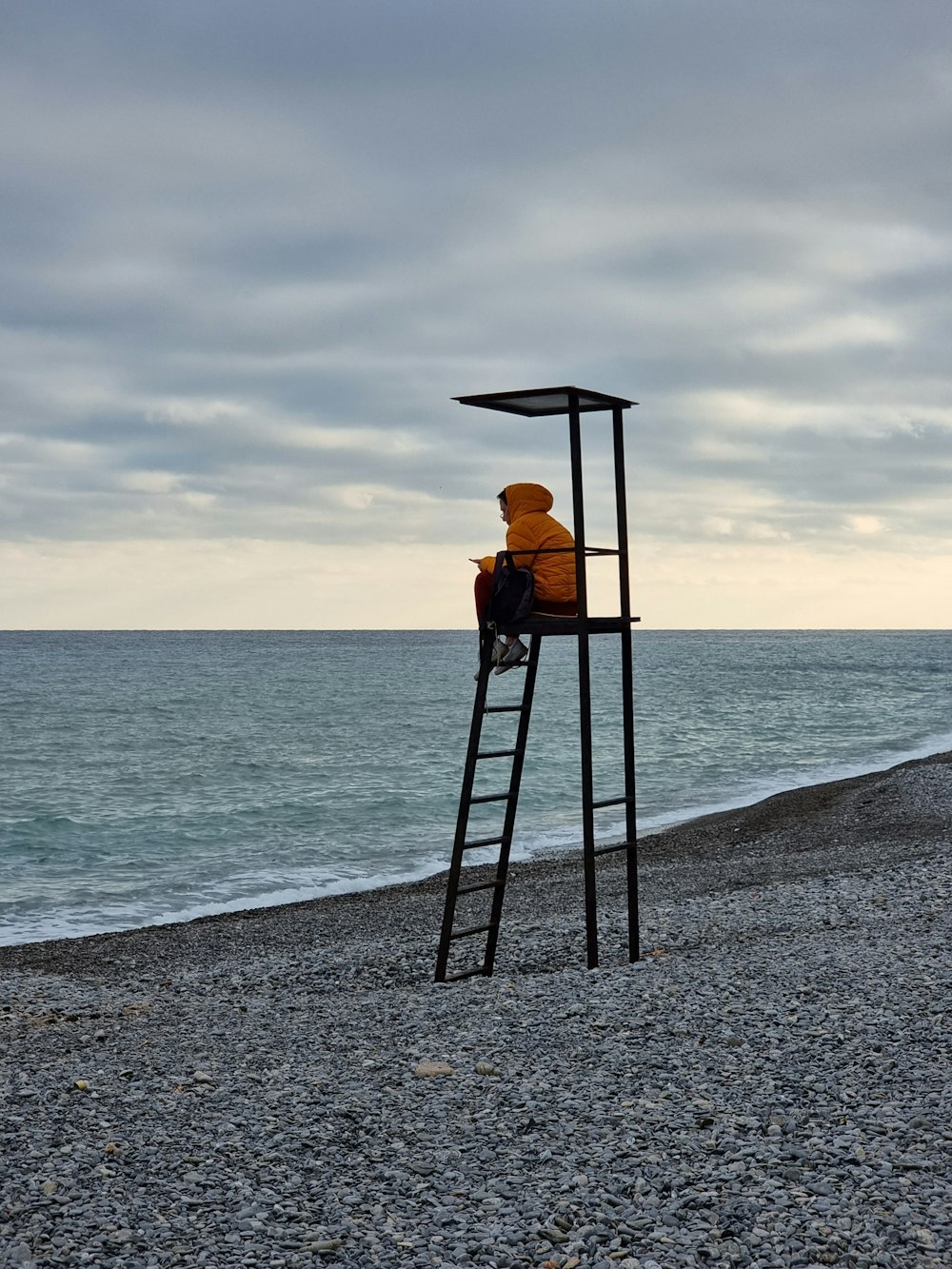 a person sitting on a chair on a beach