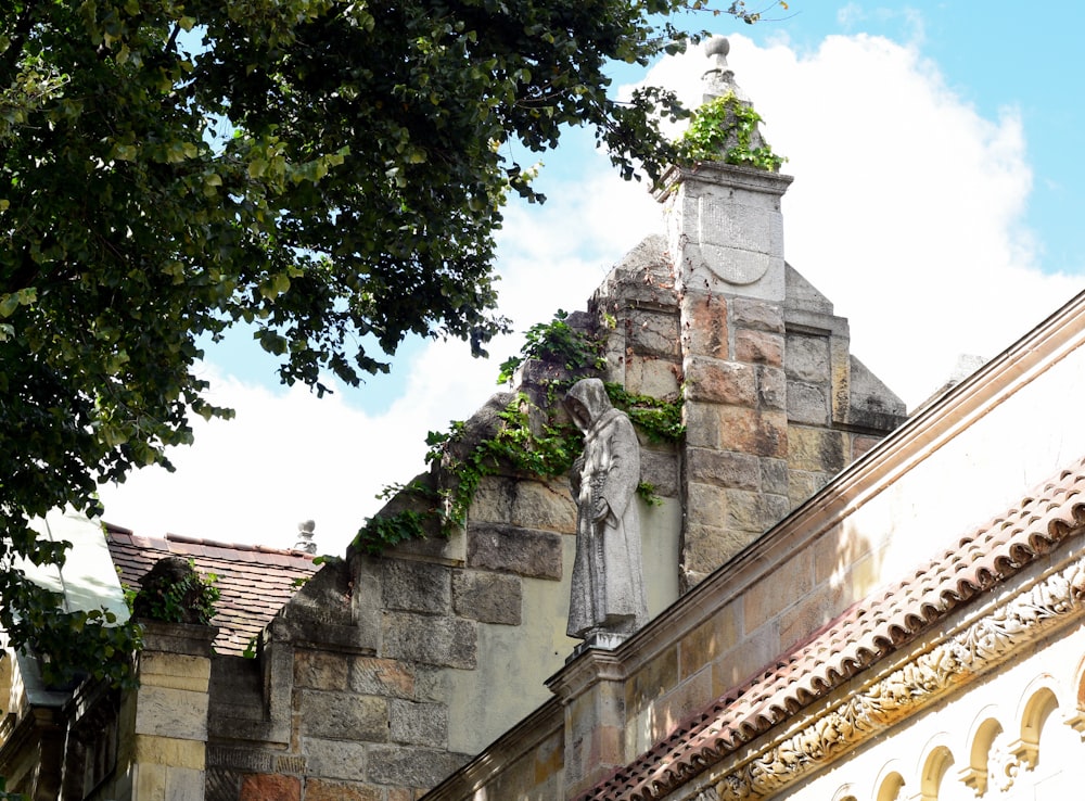 a stone building with a statue on top