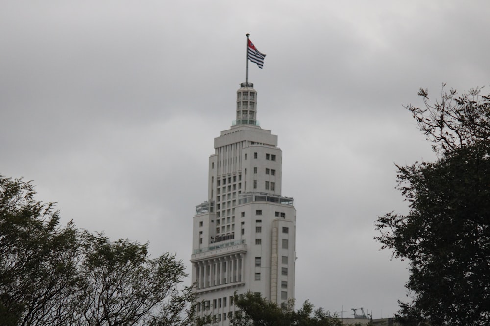 a tall white building with a flag on top