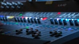 Close-up of a sound mixing console with colorful lights.