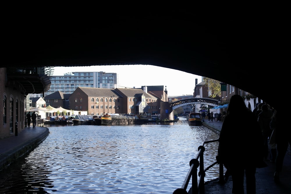 a person standing on a bridge over a river with buildings on either side