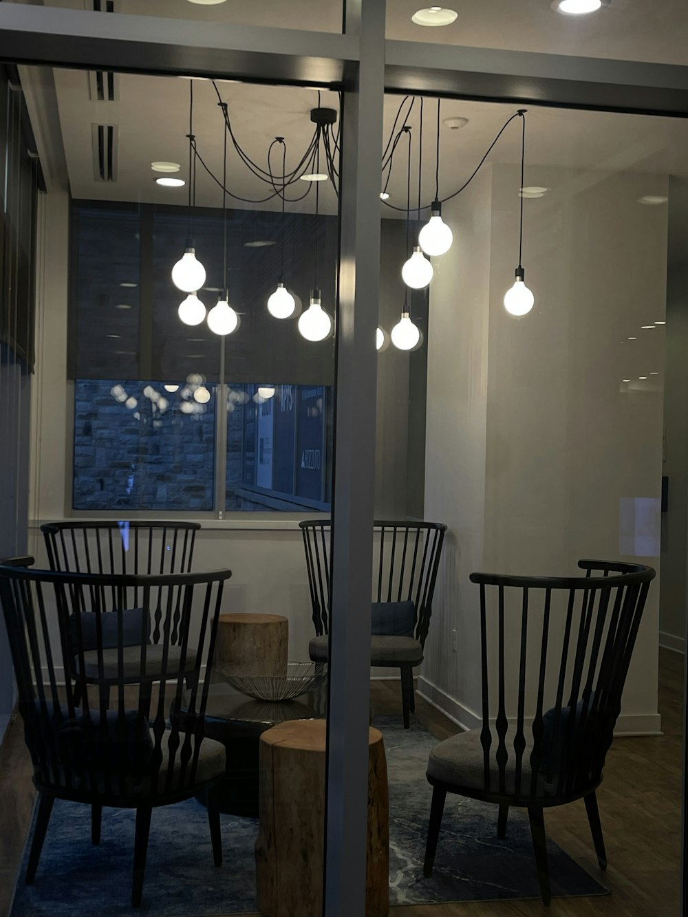 a room with a table chairs and a window with lights