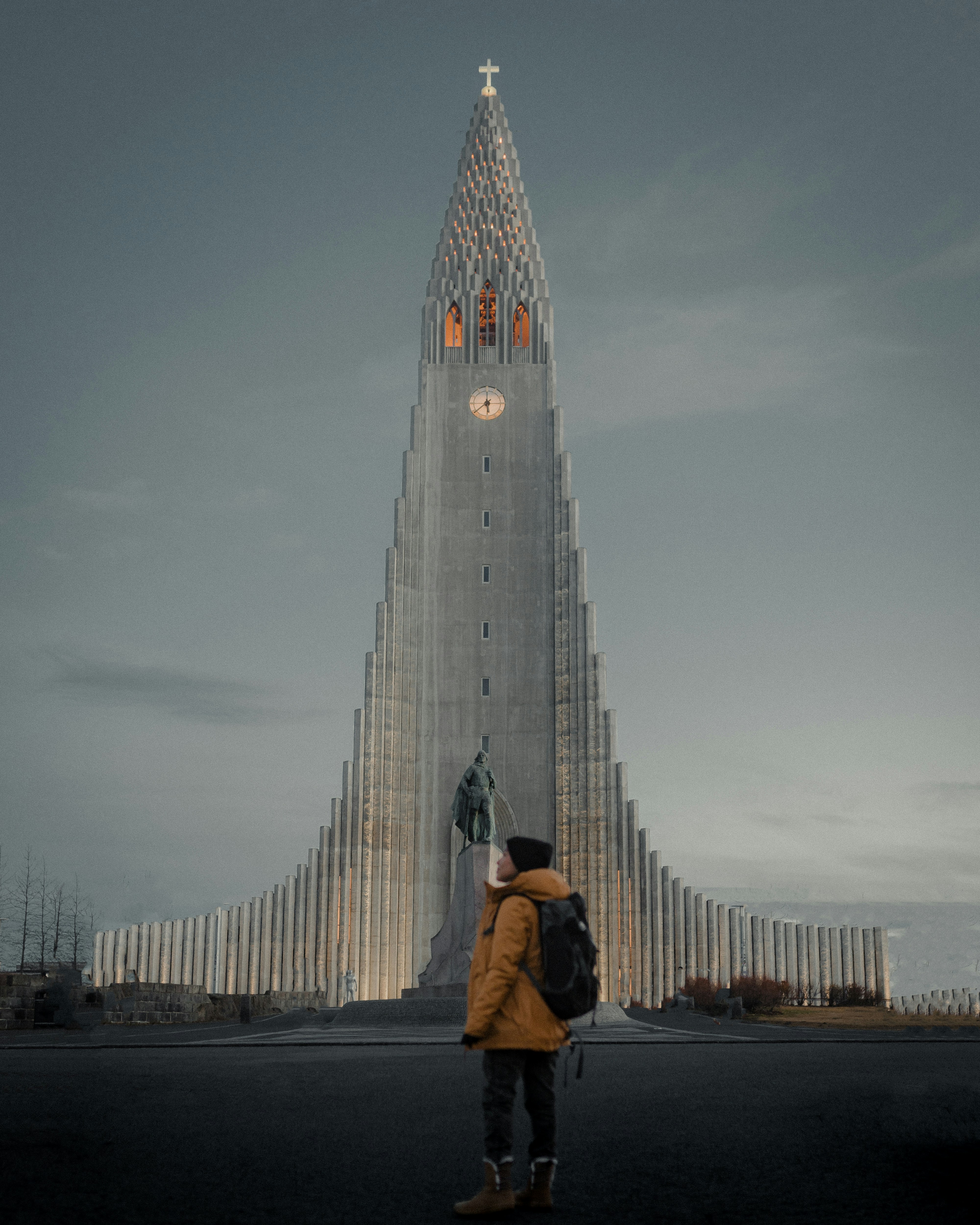 une personne debout devant un grand immeuble avec Hallgrímskirkja en arrière-plan