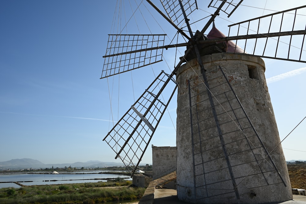 un moulin à vent à côté d’un plan d’eau