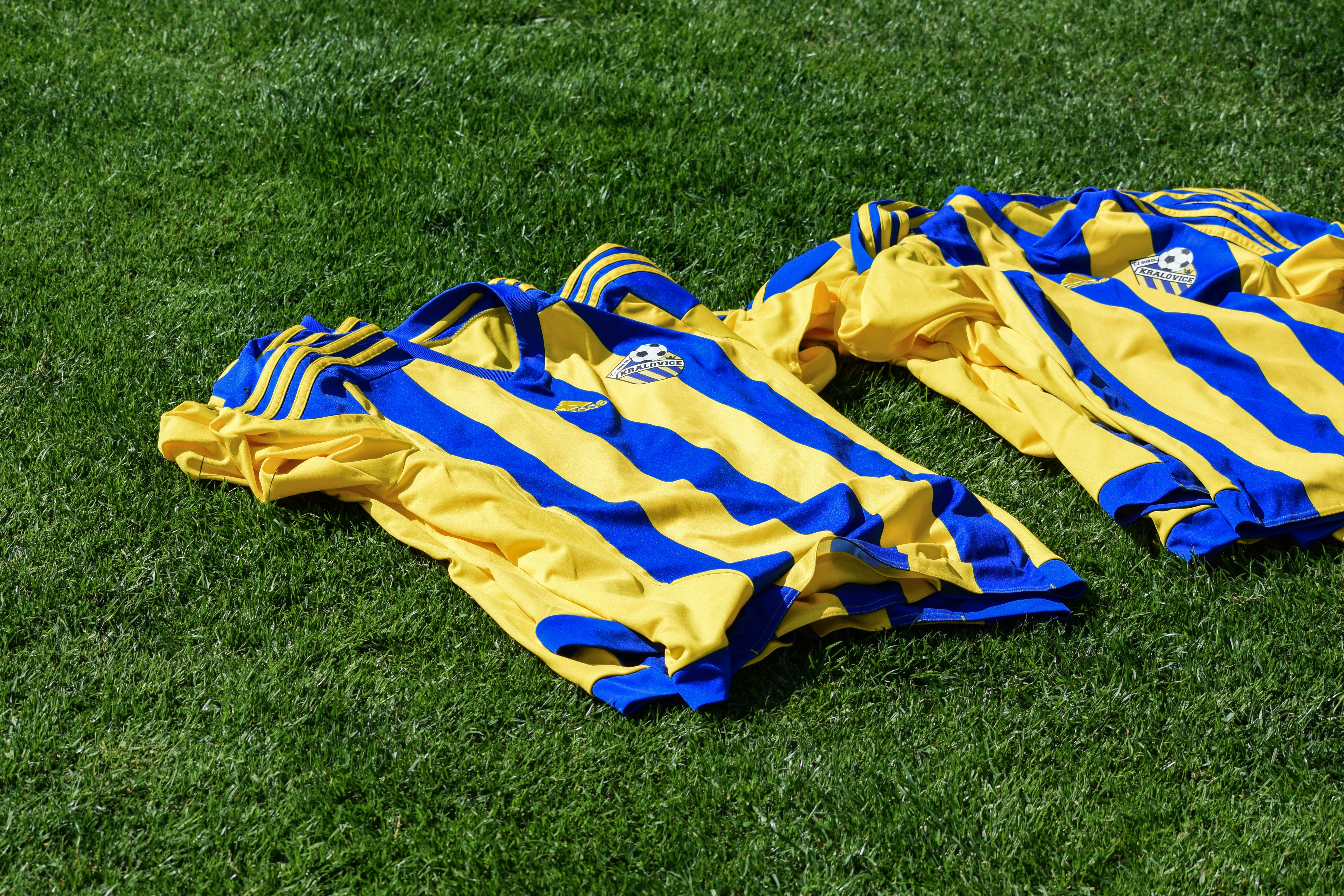 a yellow and blue striped blanket on grass