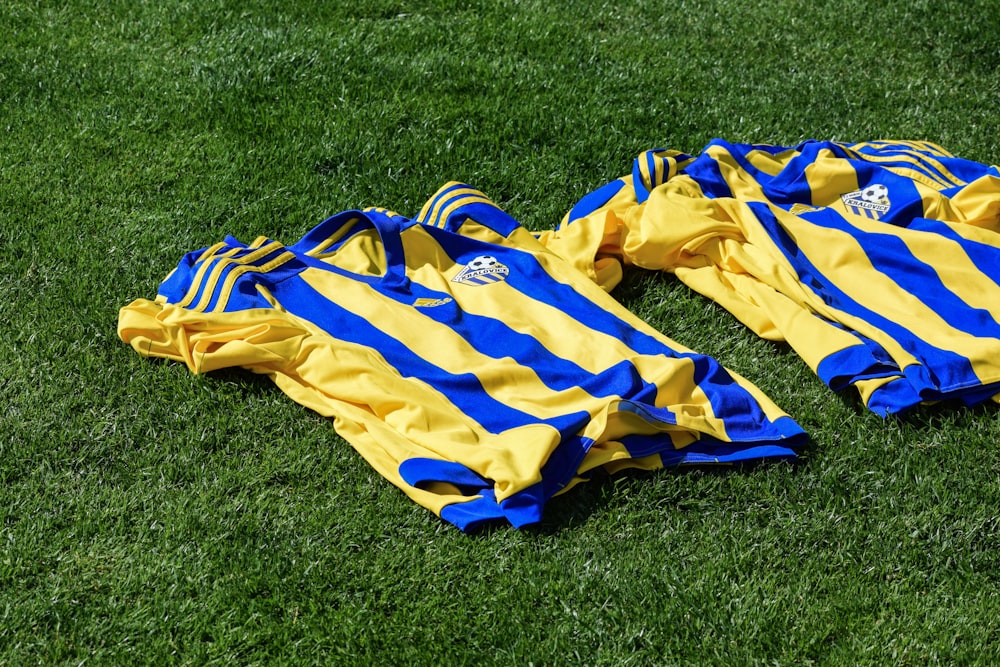 a yellow and blue striped blanket on grass