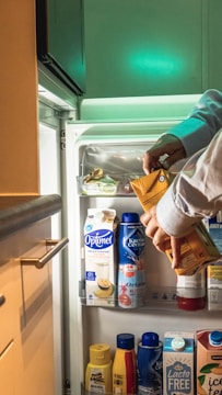 a person putting food in a refrigerator