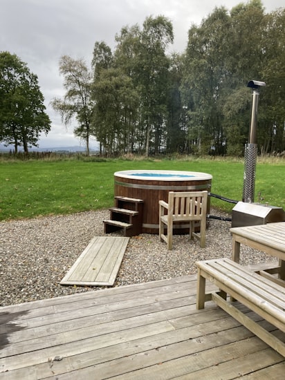Timber lodge with decking and a private hot tub at Percy Wood, Northumberland