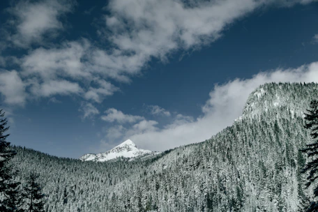 a snowy mountain with clouds