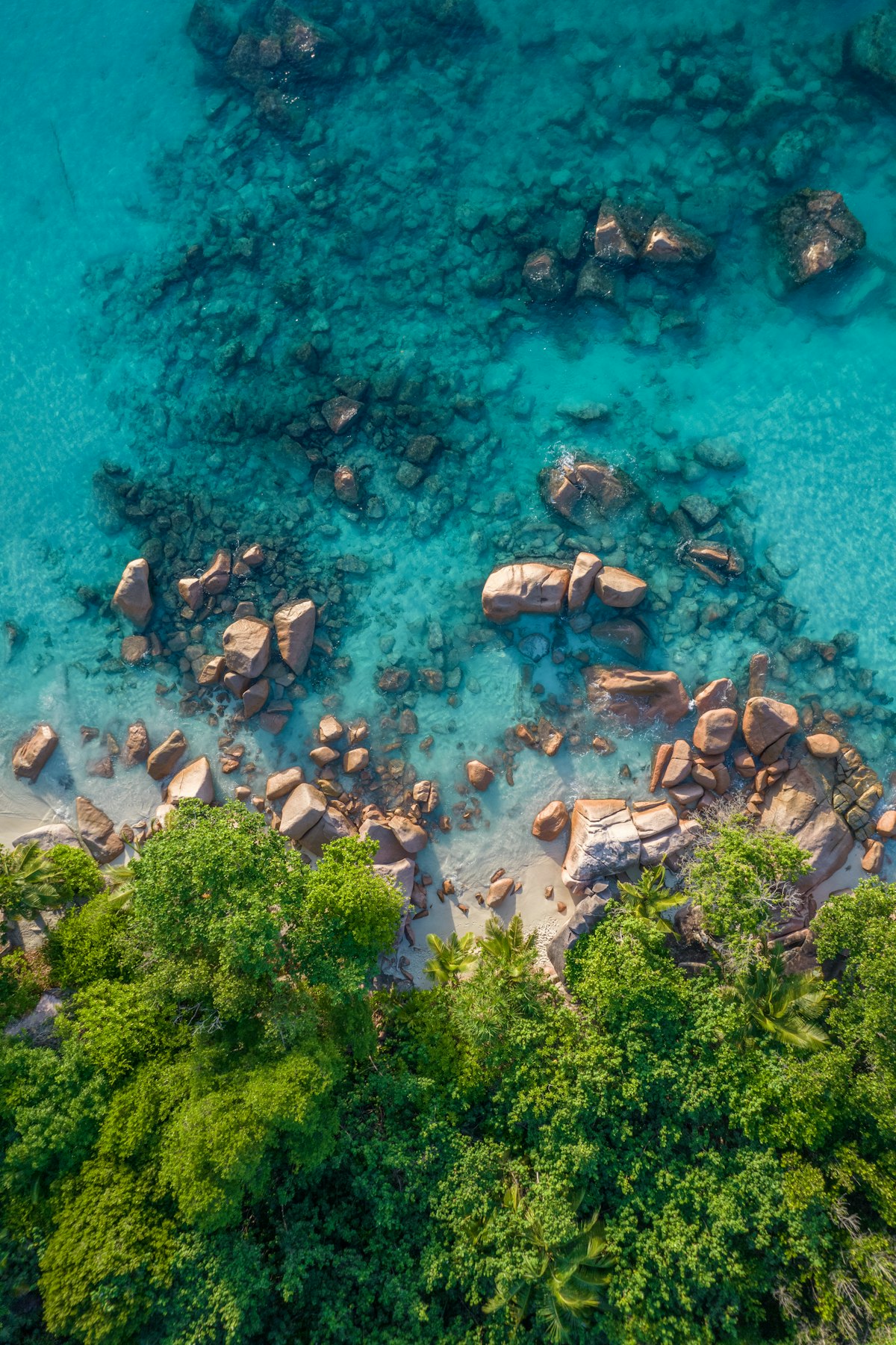 Seychelles October — the iconic turquoise lagoon flanked by giant granite rocks and coconut palms in perfect inter-monsoon calm
