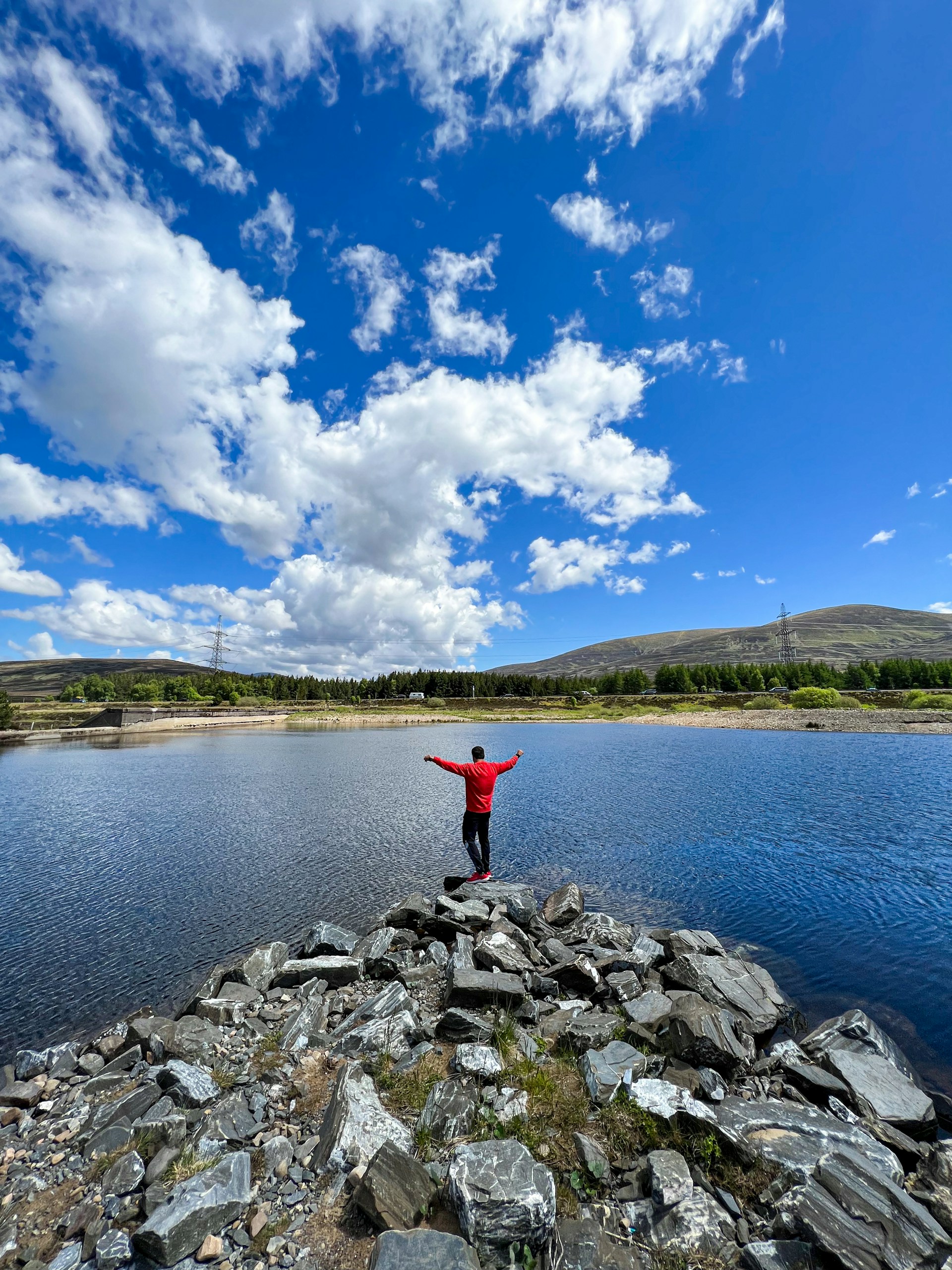a person standing on rocks by a body of water
