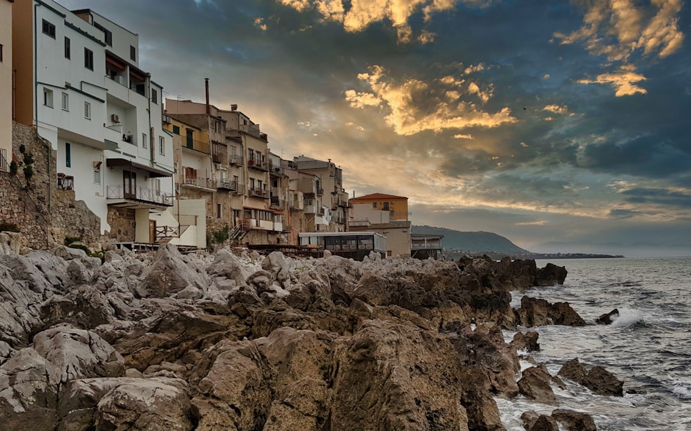 a group of buildings on a rocky shore