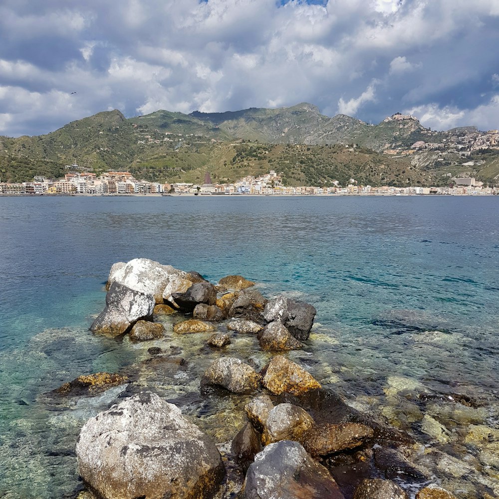 a rocky beach with a town in the distance