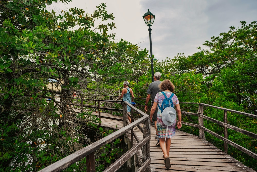 people walking on a wooden bridge