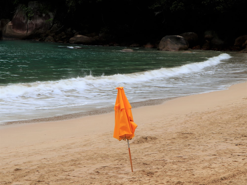 an orange umbrella on a beach