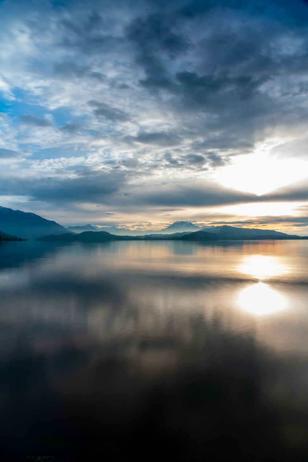 a body of water with clouds above it