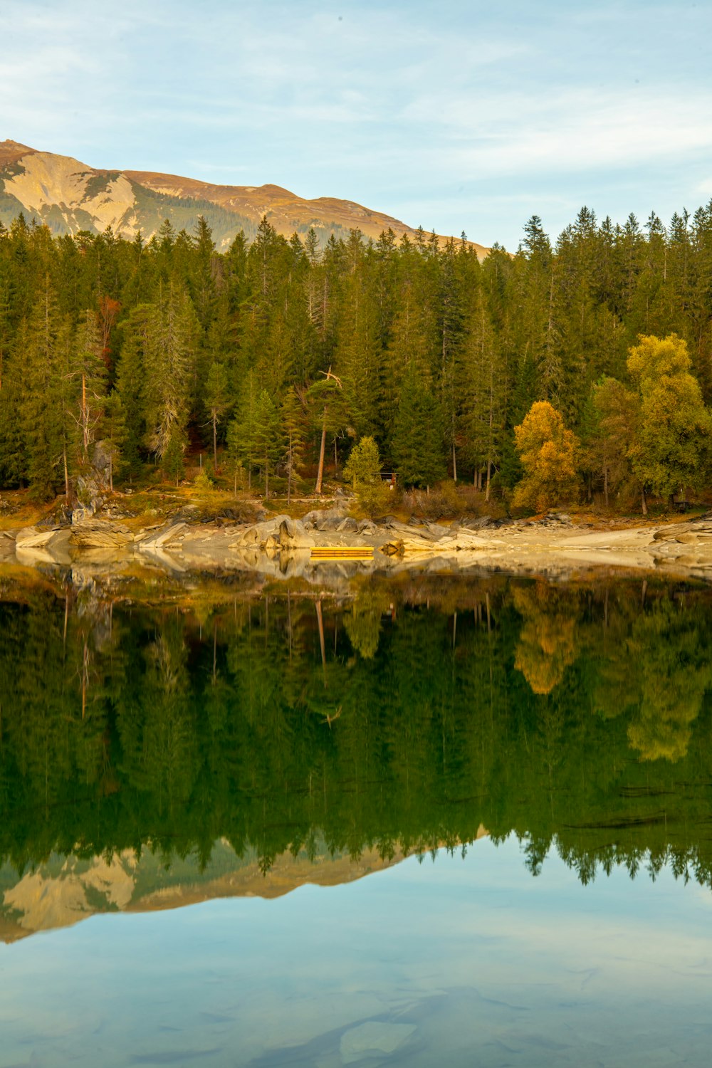 um lago com árvores e montanhas ao fundo