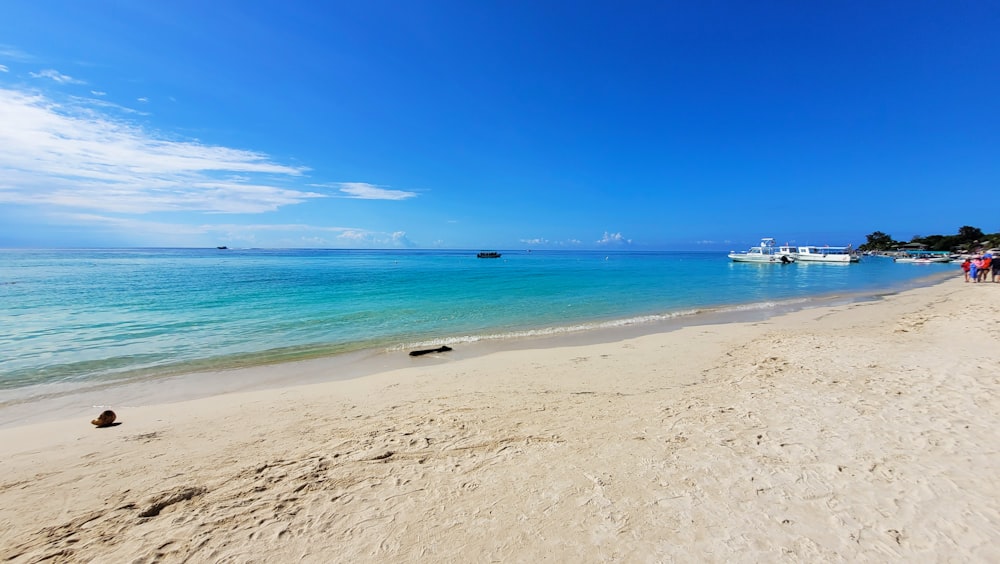 a sandy beach with boats in the water