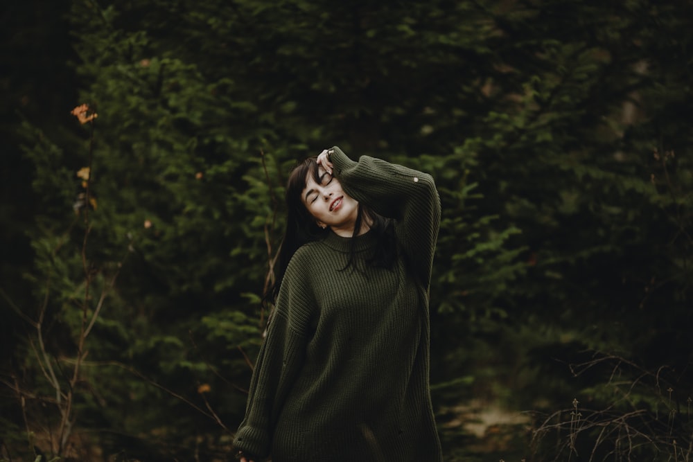 a person wearing a hat and standing in a forest